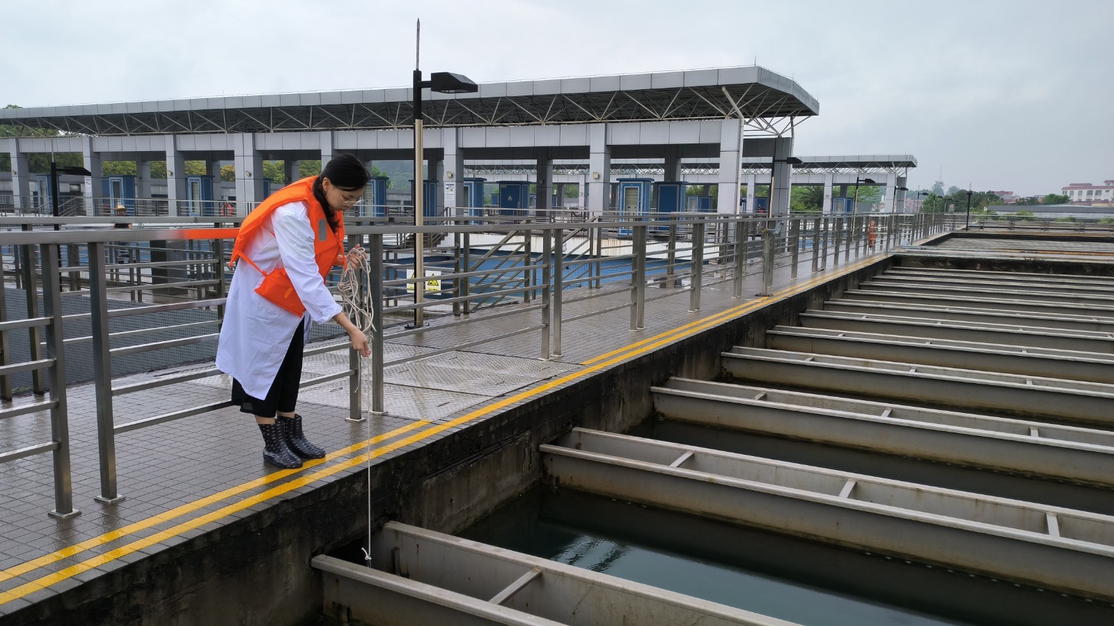 水務(wù)集團(tuán)第六水廠水質(zhì)化驗員對平流池水質(zhì)進(jìn)行取樣檢測_副本.jpg